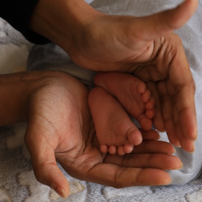 A parent holding their baby’s tiny feet